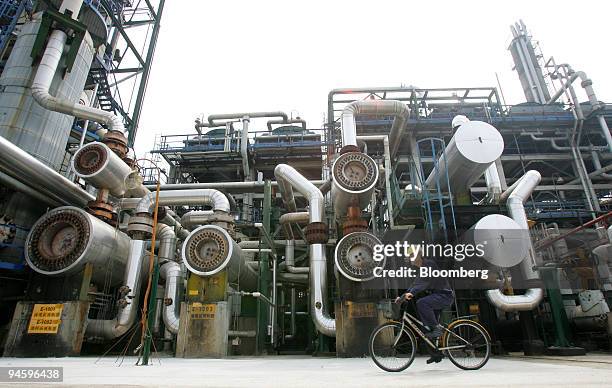 Worker bikes past refining equipment in a CPC Corp. Refinery in Taoyuan, Taiwan, on Tuesday, May 15, 2007. CPC Corp., Taiwan, the island's state oil...