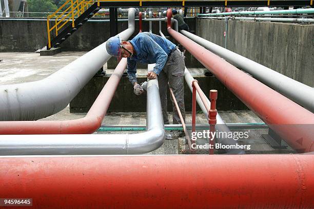 Worker paints pipes in a CPC Corp. Refinery in Taoyuan, Taiwan, on Tuesday, May 15, 2007. CPC Corp., Taiwan, the island's state oil company, is a is...