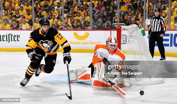 Brian Elliott of the Philadelphia Flyers poke checks the puck against Bryan Rust of the Pittsburgh Penguins in Game Two of the Eastern Conference...