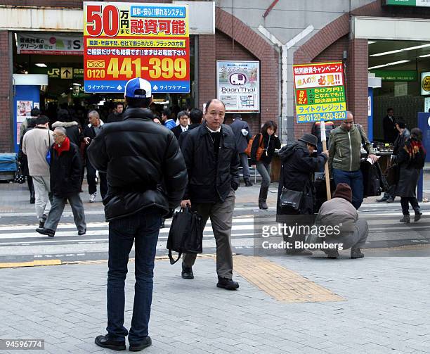 Day laborers stand with sign-boards in front of a railway station exit in Tokyo, on Wednesday, Jan. 24, 2007. Day laborers act as human sign boards,...