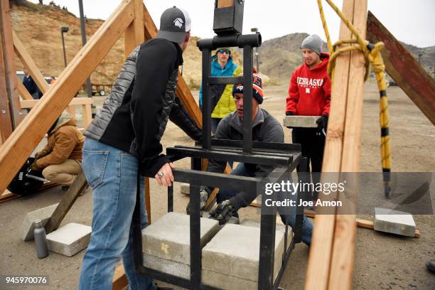 Zach Reuer mechanical engineer watches Will Buckles a petroleum engineer adjust the weights on the the Mile High Flyer as they load up during the...