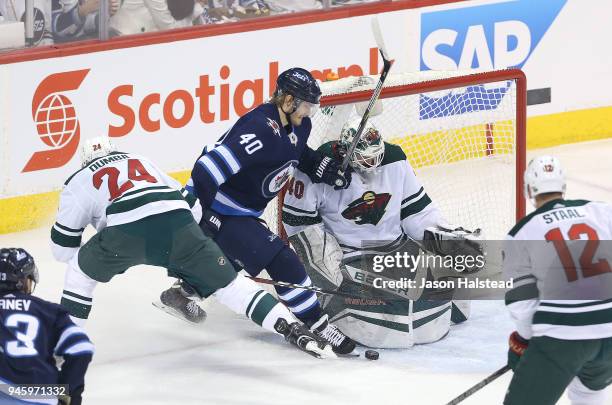 Joel Armia of the Winnipeg Jets looks for a rebound in front of Matt Dumba and Devan Dubnyk of the Minnesota Wild in Game Two of the Western...