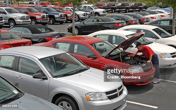 Martin Goffe checks under the hood of a 2007 Dodge Avenger at the Arrigo Chrysler Jeep Dodge dealership in West Palm Beach, Florida, on Monday, May...