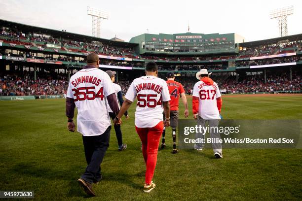 Boston Marathon bombing rescuer Carlos Arredondo and his wife Melida, and survivors Jeff Bauman and Nicole Simmonds are introduced during a ceremony...