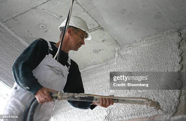 Hochtief employee Ernst Keil sprays insulation onto walls on a Hochtief construction site for the Wilhelmsdorfer-Arkaden shopping center in Berlin,...