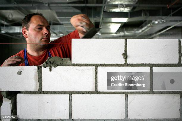 Hochtief employee Janusz Lisek builds a wall on a Hochtief construction site for the Wilhelmsdorfer-Arkaden shopping center in Berlin, Germany,...