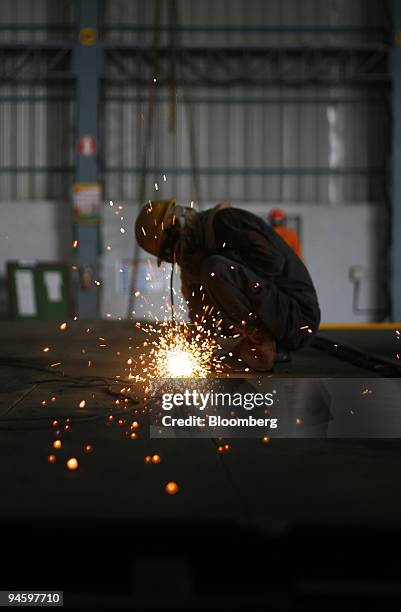 Larsen & Toubro Ltd. Employee grinds metal plates in the company's ship building yard in Hajira, India, on Tuesday, Oct. 9, 2007. Larsen & Toubro...