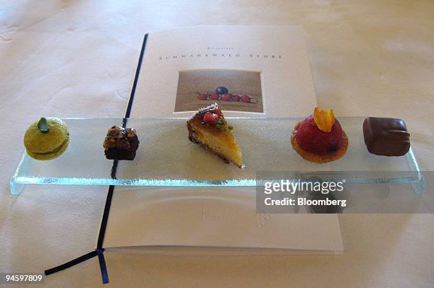 Petits fours sit on a tray on top of the restaurant's menu at the Schwarzwaldstube restaurant in the Traube Tonbach hotel in Bauersbronn, Germany,...