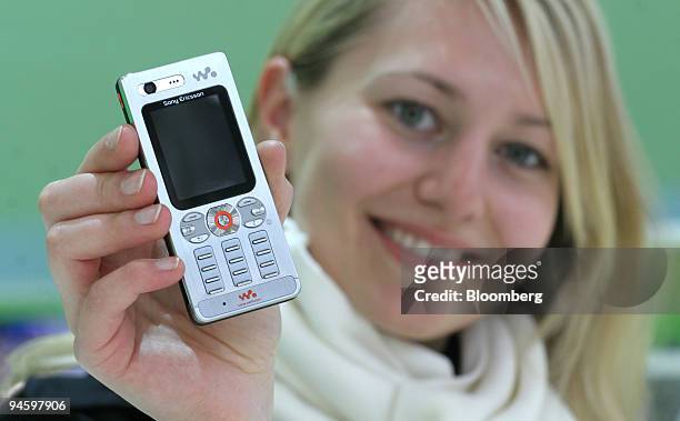 A model holds the new Sony Ericsson W880i mobile phone at the