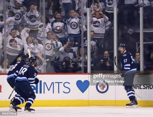 Andrew Copp and Bryan Little of the Winnipeg Jets race across the ice to celebrate a second period goal against the Minnesota Wild with goal-scorer...