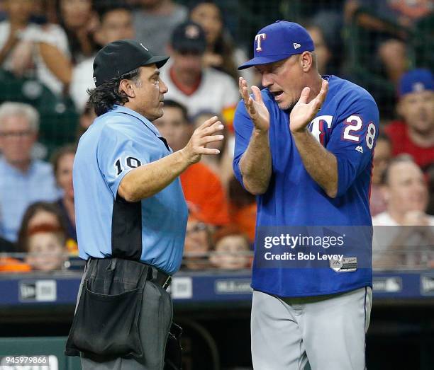 Manager Jeff Banister of the Texas Rangers argues with home plate umpire Phil Cuzzi as to whether Jake Marisnick of the Houston Astros fouled the...