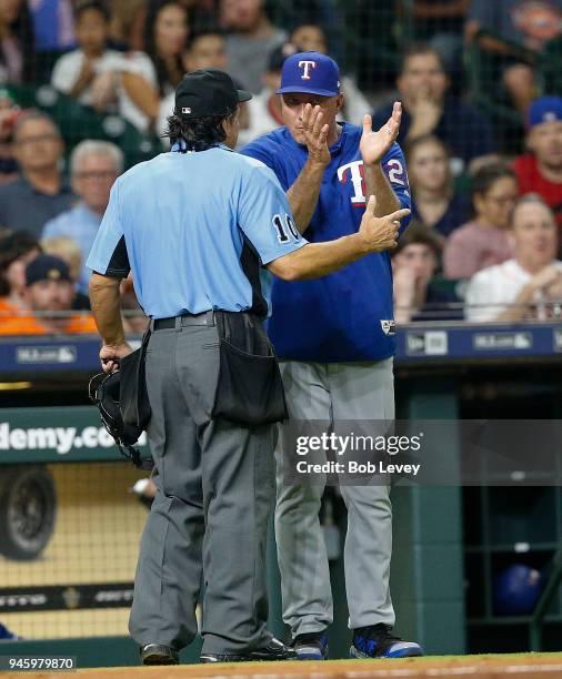 Manager Jeff Banister of the Texas Rangers argues with home plate umpire Phil Cuzzi as to whether Jake Marisnick of the Houston Astros fouled the...