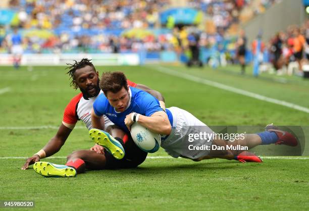 James Fleming of Scotland holds off Nathan Baramun of Papua New Guinea to score a try during Rugby Sevens Men's Pool A match between Scotland and...