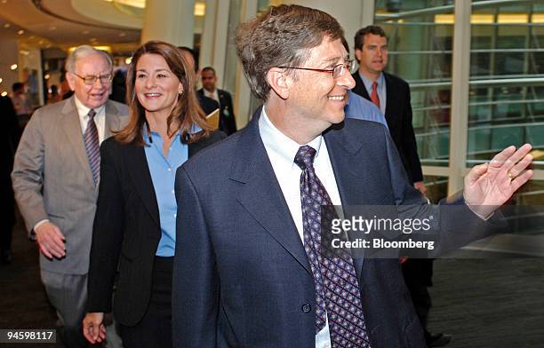 Bill Gates, chairman of Microsoft Corp., foreground, waves to Bloomberg employees as he and his wife, Melinda Gates, and Warren Buffett, chairman and...