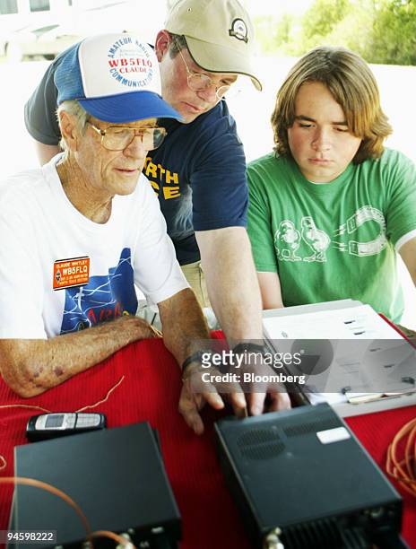 Claude Whitley, left to right, Jim Byford, and Christopher Byford set up a ham radio during The National Association for Amateur Radio Field Day in...