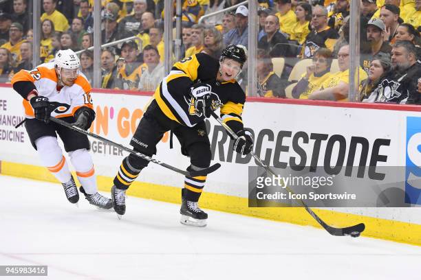 Pittsburgh Penguins defenseman Olli Maatta passes the puck while Philadelphia Flyers left wing Michael Raffl forechecks during the first period. The...