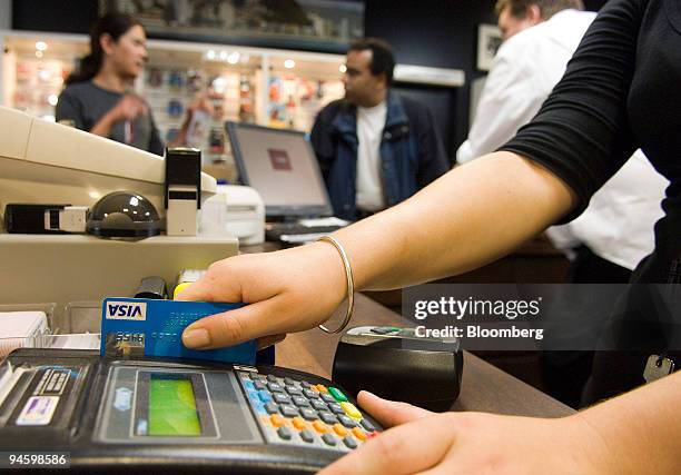 Sales clerk swipes a customer's Visa card at a shop in Wellington, New Zealand, on Tuesday, Jan. 15, 2008. New Zealand consumer spending on debit,...