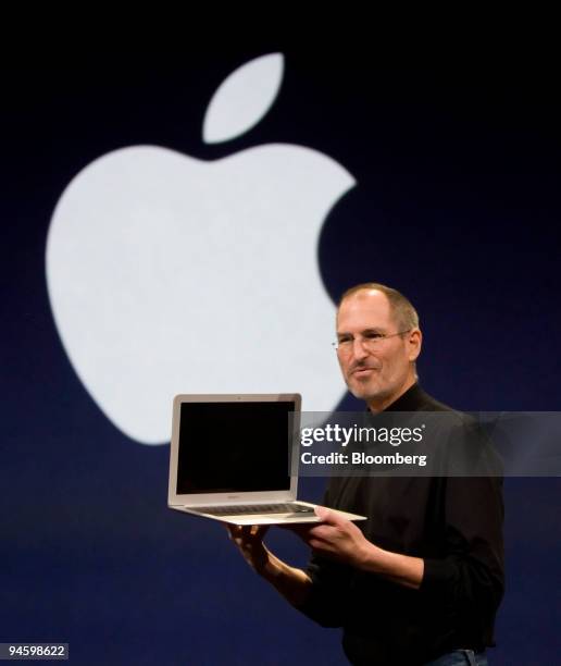 Steve Jobs, chief executive officer of Apple Inc., displays the new MacBook Air laptop computer during his keynote address at the MacWorld conference...