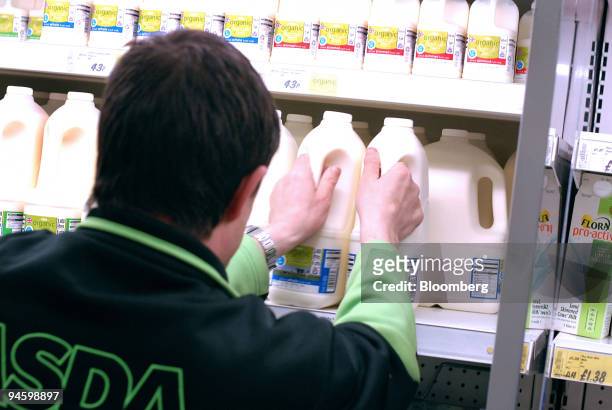 Asda employee replenishes milk shelves at a supermarket in Brighton, U.K., Friday, May 11, 2007. Milk prices worldwide are rising at the fastest rate...