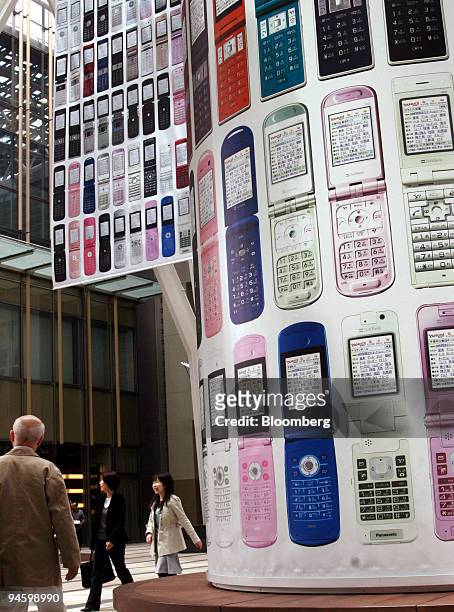 Pedestrians walk past a Softbank Corp. Mobile phone advertising display in Tokyo, Japan, on Monday, May 7, 2007. Softbank Corp., Japan's...