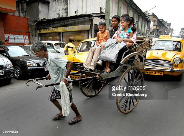 Rickshaw puller tows a family of four down a street in Kolkata, India, March 13, 2007. There are about 18,000 rickshaw pullers in Kolkata, the...