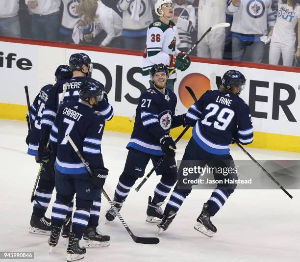 Paul Stastny, Ben Chiarot, Tyler Myers and Nikolaj Ehlers of the Winnipeg Jets congratulate teammate Patrik Laine on his goal against the Minnesota...