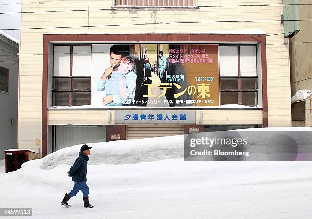 Resident walks past a boarded-up building with a poster for the film, "East of Eden," in Yubari, Japan, on Tuesday, Mar. 13, 2007. This building used...