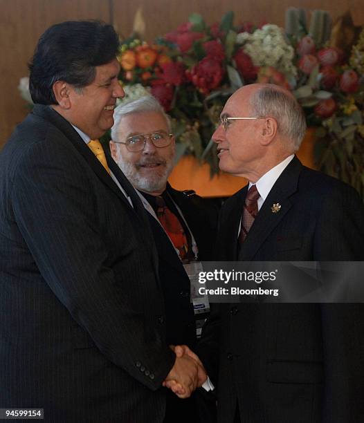 John Howard, Australia's prime minister, greets Alan Garcia, Peru's president, ahead of official group dialogue sessions on day seven of the...