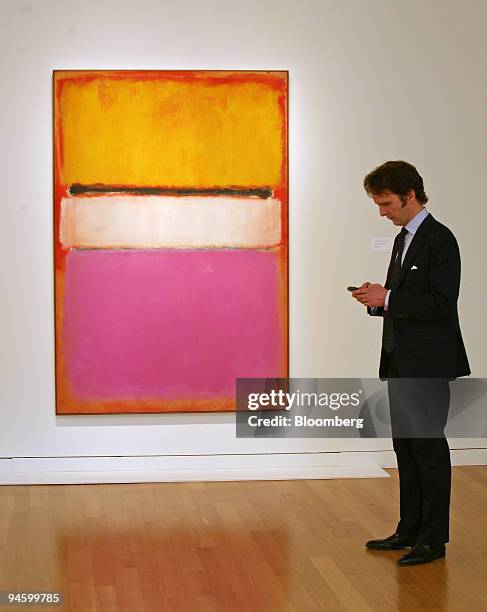 Tobias Meyer, global head of contemporary art for Sotheby's, works on his PDA while standing beside Mark Rothko's "White Center " at Sotheby's on...