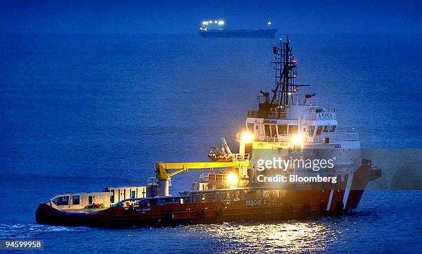 Rescue tug boat pulls cables attached to the bulk tanker container ship Pasha Bulker during a night-time refloating attempt on Nobby's beach at the...