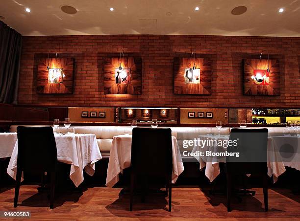 Tables are set for patrons in the dining room of Fiamma restaurant in New York, U.S., on Monday, Oct. 8, 2007. Fiamma, an expensive Manhattan eatery...