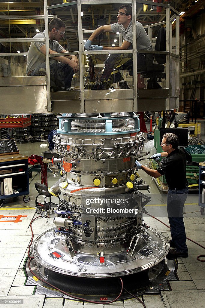 Technicians work on a General Electric Co. GE-90 jet engine