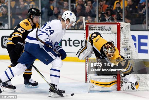 Boston Bruins goalie Tuukka Rask pins the puck to the cage watched closely by Toronto Maple Leafs right wing Kasperi Kapanen during Game 1 of the...