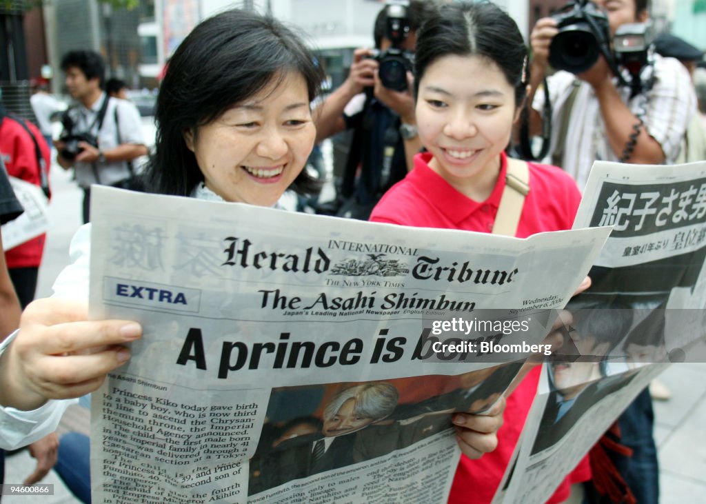 Two women read the daily the newspapers announcing the birth