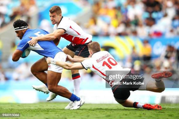 Neria Fomai of Samoa is tackled by Tom Mitchell and Ruaridh McConnochie of England during the Rugby Sevens match between England and Samoa on day 10...