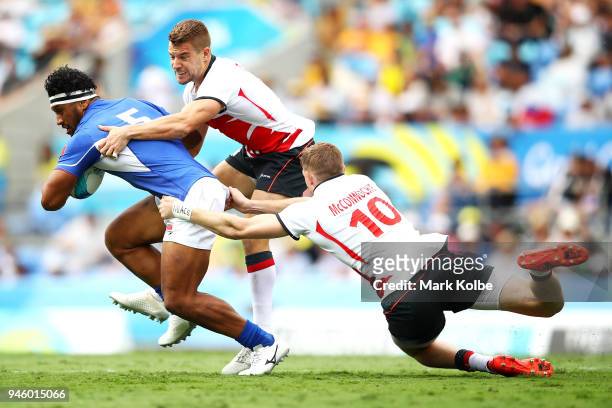Neria Fomai of Samoa is tackled by Tom Mitchell and Ruaridh McConnochie of England during the Rugby Sevens match between England and Samoa on day 10...