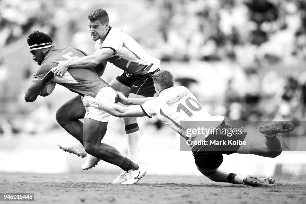 Neria Fomai of Samoa is tackled by Tom Mitchell and Ruaridh McConnochie of England during the Rugby Sevens match between England and Samoa on day 10...