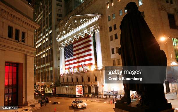 Statue stands across from the New York Stock Exchange, center, in downtown Manhattan, New York, at night on Thursday, November 3, 2006.