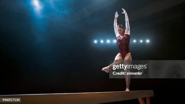 vrouwelijke turnster op de evenwichtsbalk - gymnastiek stockfoto's en -beelden