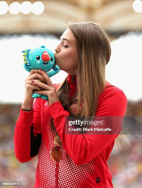 Gold medalist Alysa Newman of Canada kisses her mascot as she celebrates during the medal ceremony for the Womens Pole Vault during athletics on day...