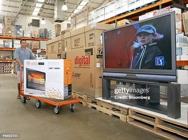 Todd Sabo pushes a 37" LCD television past a display of 62" TV's inside a Costco in San Diego, California, Wednesday, June 21, 2006.