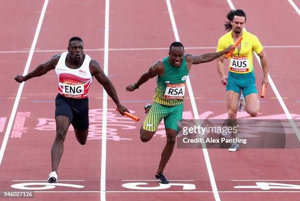 Harry Aikines-Aryeetey of England crosses the line to win gold ahead of Akani Simbine of South Africa and Josh Clarke of Australia in the Men's 4x100...