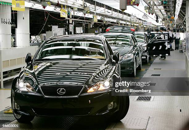 Workers check Toyota Motor Corp.'s luxury series Lexus LS600 hybrid sedans on the production line at its Tahara plant in Tahara, central Japan,...