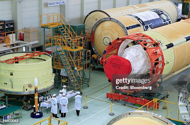 Journalists inspect an H2A rocket during a media tour of Mitsubishi Heavy Industries' Ohe plant in Aichi prefecture, central Japan, on Thursday, June...