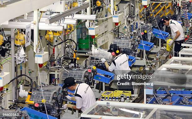 Workers assemble V8 engines of Toyota Motor Corp.'s luxury series Lexus LS600 hybrid sedan on the production line at its Tahara plant in Tahara,...