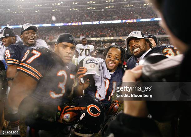 Chicago Bears running back Jason McKie, left, wide receiver Rashied Davis, and running back Cedric Benson hold NFC Champions hats after the Chicago...