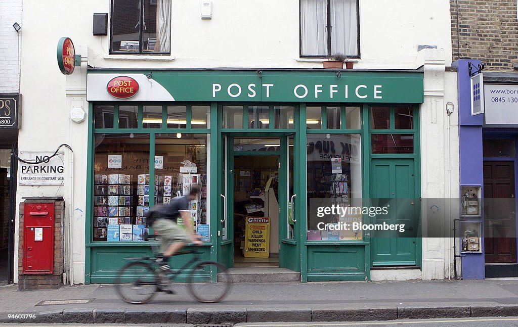 A cyclist rides by a post office in the Stoke Newington section of