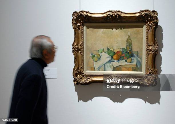 Visitor to the new National Art Center admires Paul Cezanne's painting, "Still Life with a Bottle," during an opening event in Tokyo, on Saturday,...