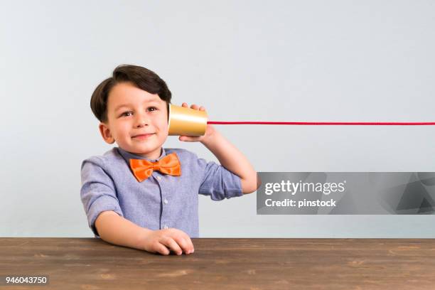 the child is using paper cup as a telephone - tin can phone stock pictures, royalty-free photos & images