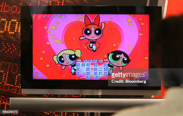 Vendor looks at Cartoon Network's Powerpuff Girls American cartooon with Chinese characters giving the dubbing credits around 5:30 p.m. On Chinese...